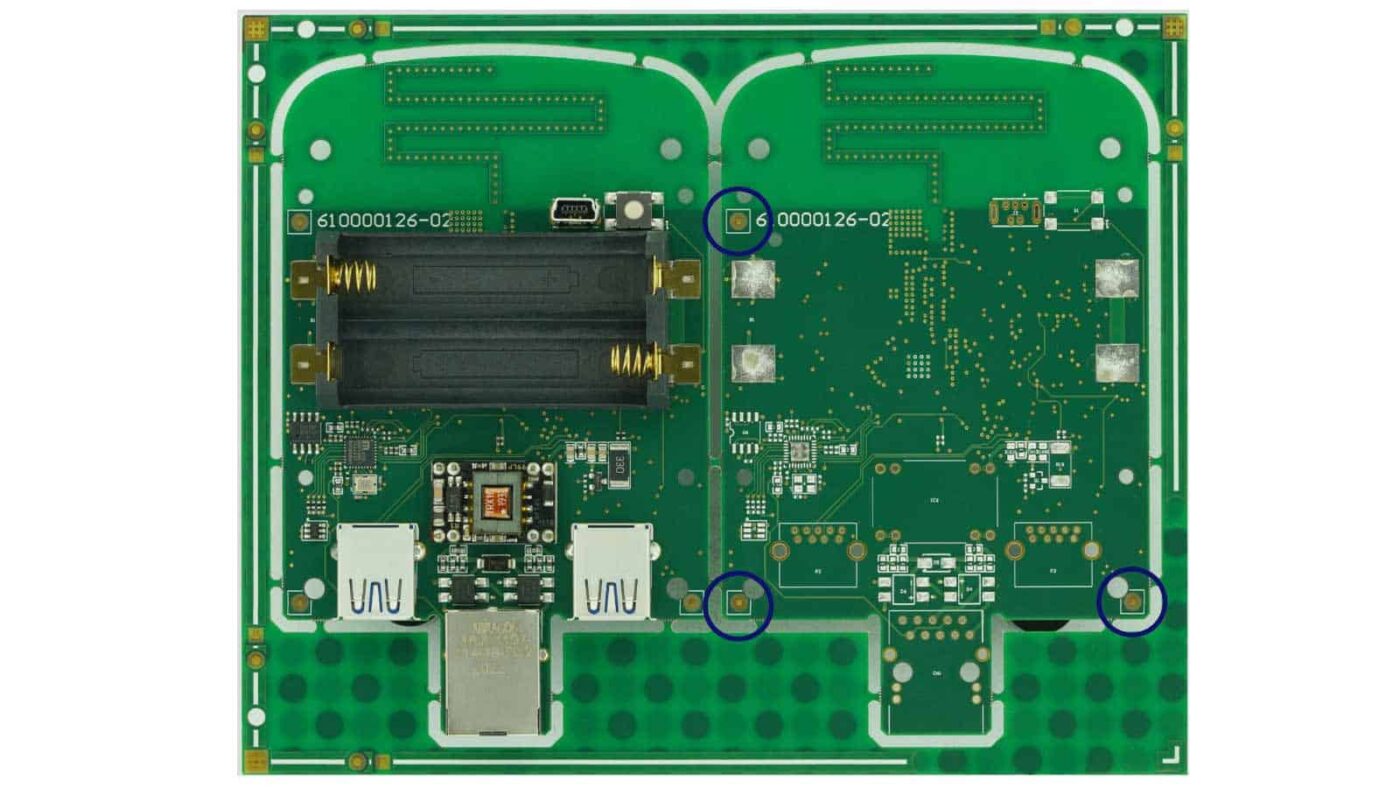 Here we see a panel with fiducials containing two PCB instances with three fiducials in each; those are circled in blue. The fiducials are at the ‘corners’ of the PCB, as far away from each other but without interfering with the functionality, like being inside the antenna keepout area.